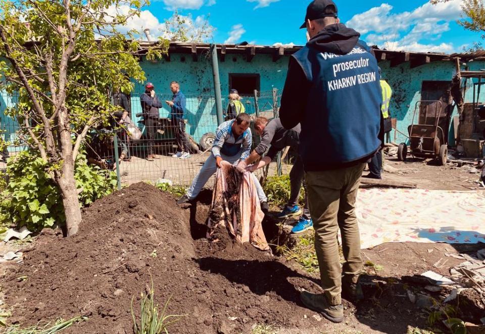 Ukrainian war crimes investigators exhume the body of Mikhayl Yerchenko from a shallow grave in his own back yard in the village of Malaya Rohan, near Kharkiv, Ukraine, May 18, 2022.  / Credit: CBS News