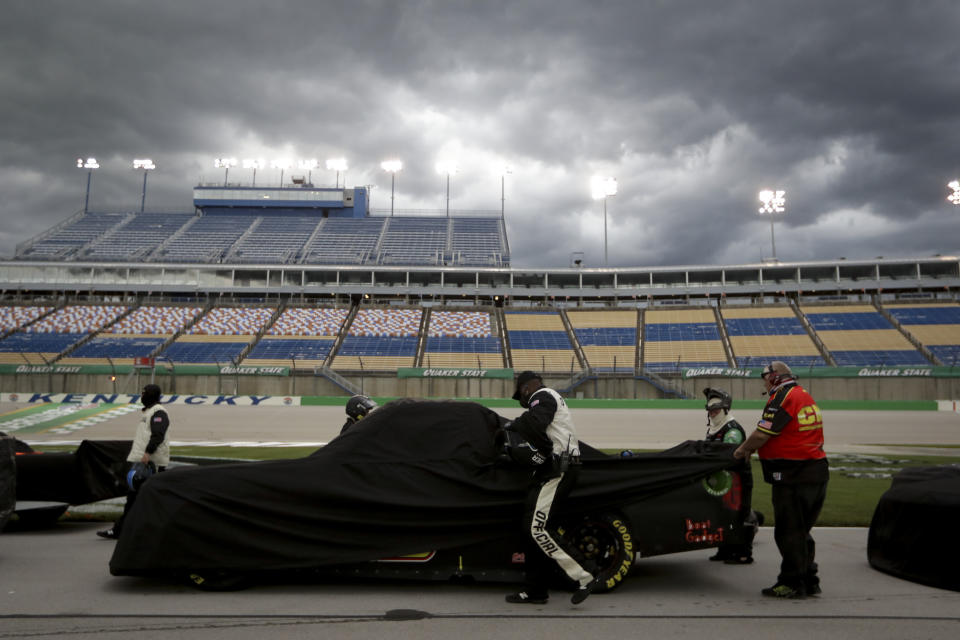 A pit crew covers a truck during a weather delay at a NASCAR Truck Series race Saturday, July 11, 2020, in Sparta, Ky. (AP Photo/Mark Humphrey)