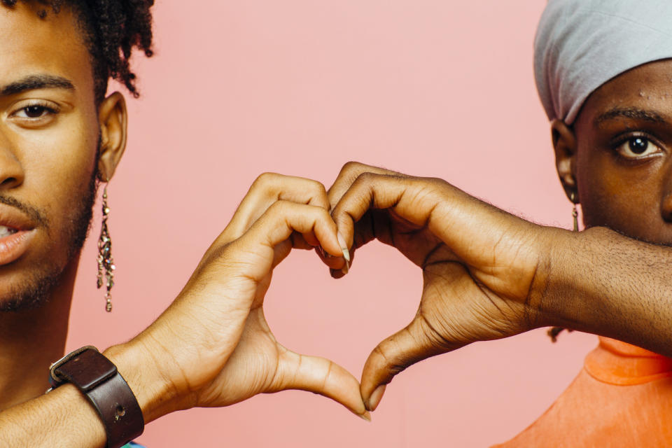 two people hold their hands together to make a heart