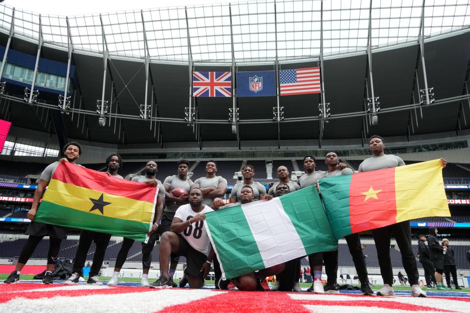 Oct 4, 2022; London, United Kingdom; Players including Tyrese Owusu-Bediako, Andy Owusu, Ebuka Emmanuel Nzekwe, Ifanyi Paul Anine, Ifeanyi Augustine Nwoye, Kenneth Odumegwu, Jason Godrick, Basil Chijoke Okoye, Ames Laoye and Chibuike Cisom Omemgboji and Arthur Mbahin pose with Ghana, Nigeria and Cameroon flags during the NFL International Combine at Tottenham Hotspur Stadium. Mandatory Credit: Kirby Lee-USA TODAY Sports