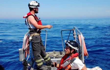 Nick Romaniuk (L) and Max Avis of the NGO SOS Mediterranee take a cigarette after rescuing hundreds of migrants off the Libyan coast May 18, 2017. Picture taken May 18, 2017. REUTERS/Steve Scherer