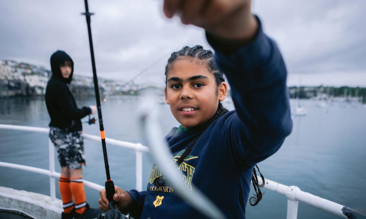 <span>Reo, who’s grandma has brought him along to learn how to fish with the Tight Lines group, shows off his catch in Falmouth.</span><span>Photograph: Luke Gartside/The Guardian</span>