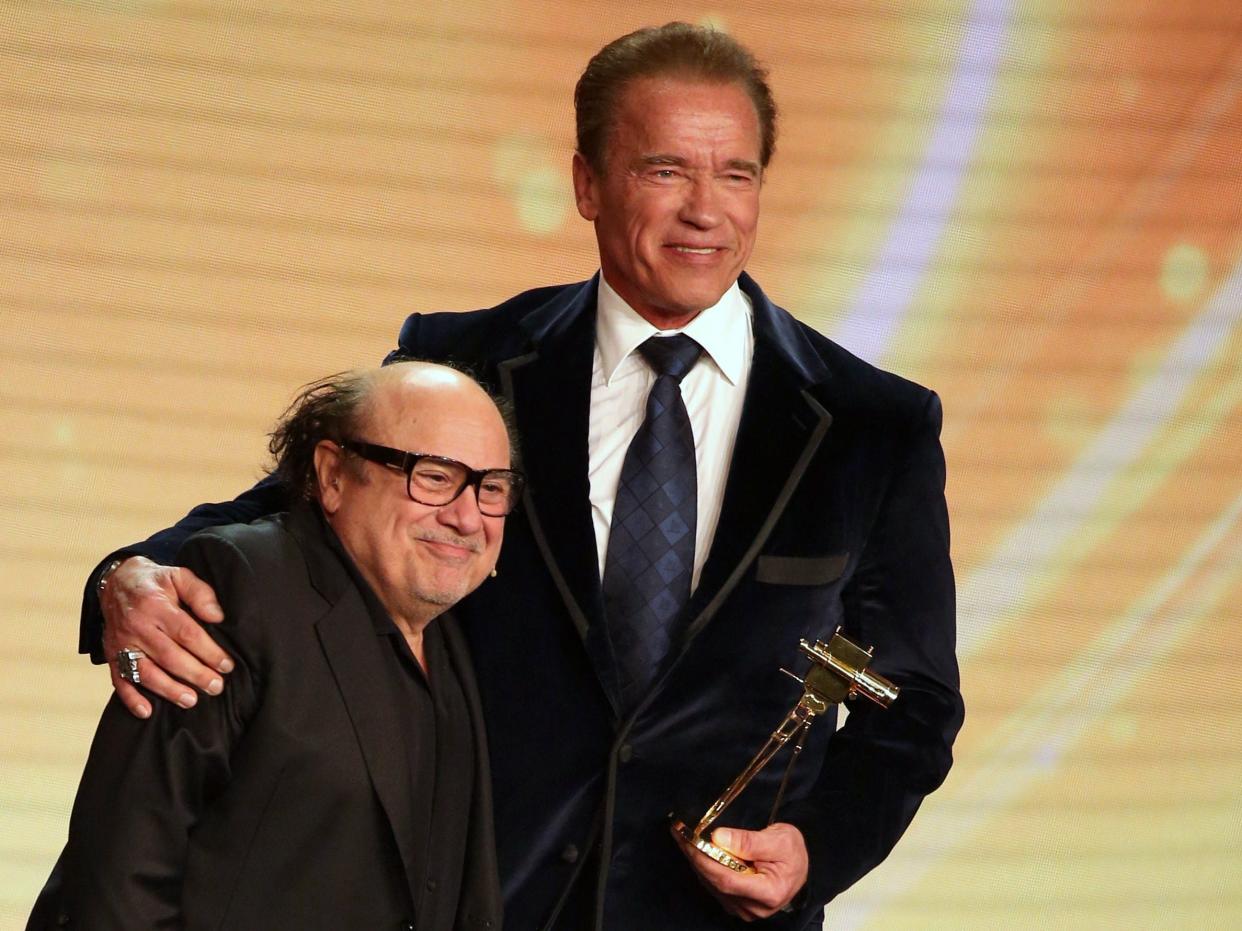 Arnold Schwarzenegger (R) poses after receiving from US actor Danny DeVito his lifetime achievement award at the annual German film and television award ceremony Golden Camera.