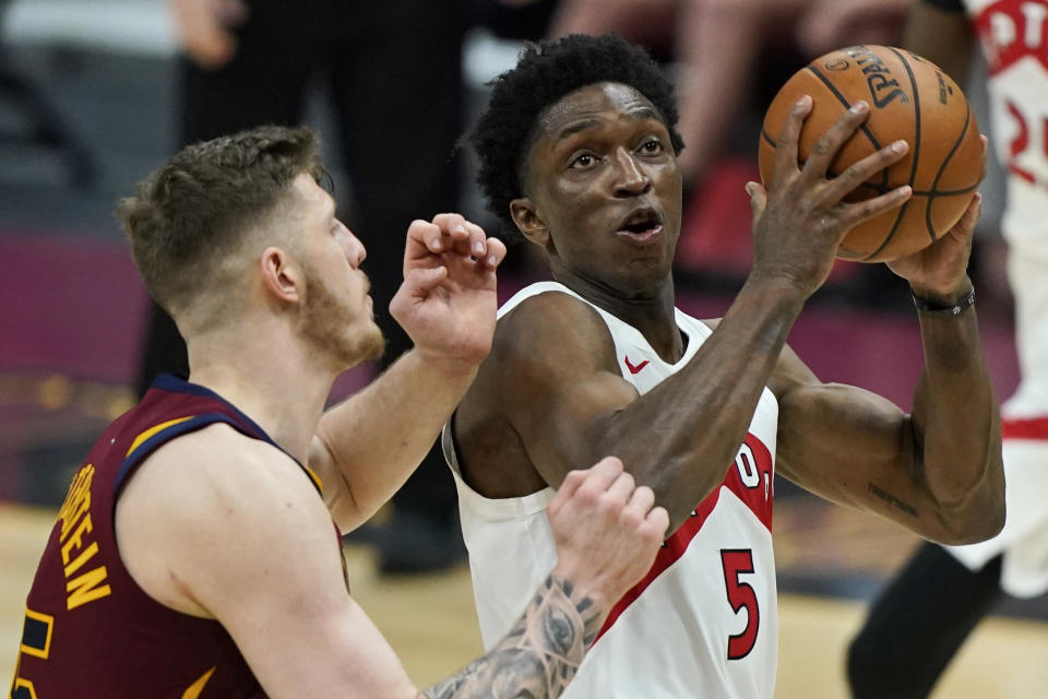 Toronto Raptors' Stanley Johnson, right, drives to the basket against Cleveland Cavaliers Isaiah Hartenstein in the second half of an NBA basketball game, Saturday, April 10, 2021, in Cleveland. (AP Photo/Tony Dejak)