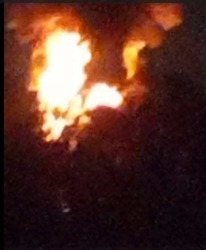 This still image from a video shot by White Lake Township resident Laun Dearman shows large flames rising from the site of an explosion at a refinery off Bogie Lake Road on Friday, November 25, 2023.