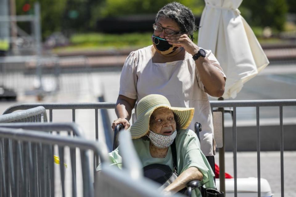 Melanie Eversley, of New York City, wipes away tears as she and her mother, Mae Eversley, 92, walk to view Lewis’s casket on Tuesday.