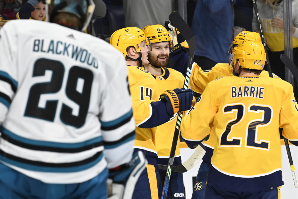 Nashville Predators center Tommy Novak (82) is congratulated by teammates after scoring his goal against the San Jose Sharks during the second period of an NHL hockey game Saturday, Oct. 21, 2023, in Nashville, Tenn. (AP Photo/Mark Zaleski)