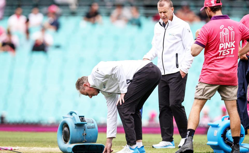 Umpires Paul Reiffel and Chris Gaffaney, pictured here inspecting the pitch during a rain delay at the SCG.