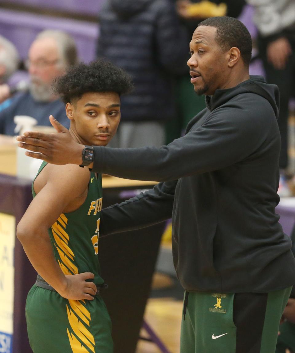 Firestone coach DeAndre Walker talks to Jemyrin Miller during the Falcons' 50-48 win over Barberton on Wednesday. [Phil Masturzo/Beacon Journal]