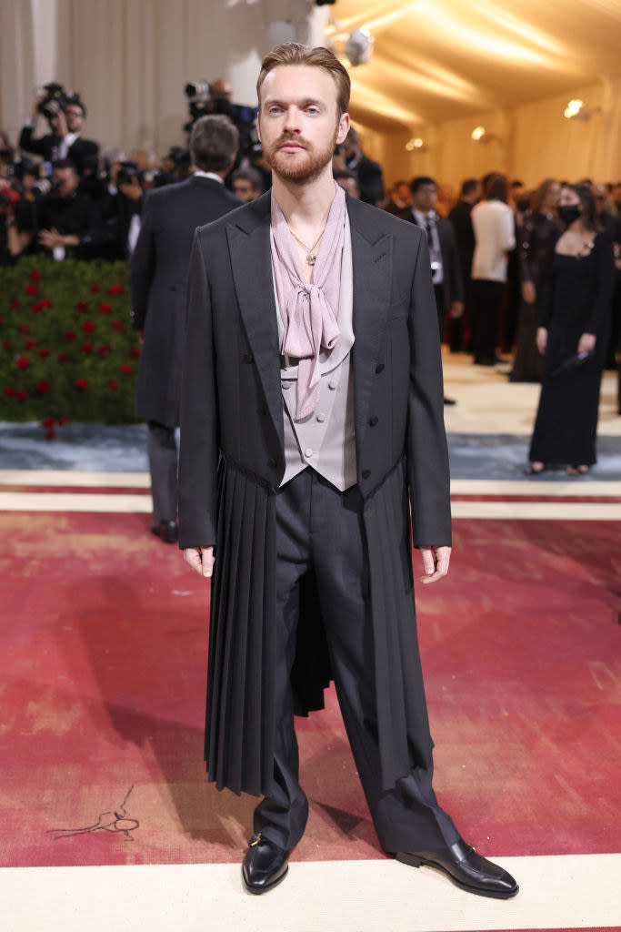 Finneas O'Connell in a suit with a long, pleated jacket