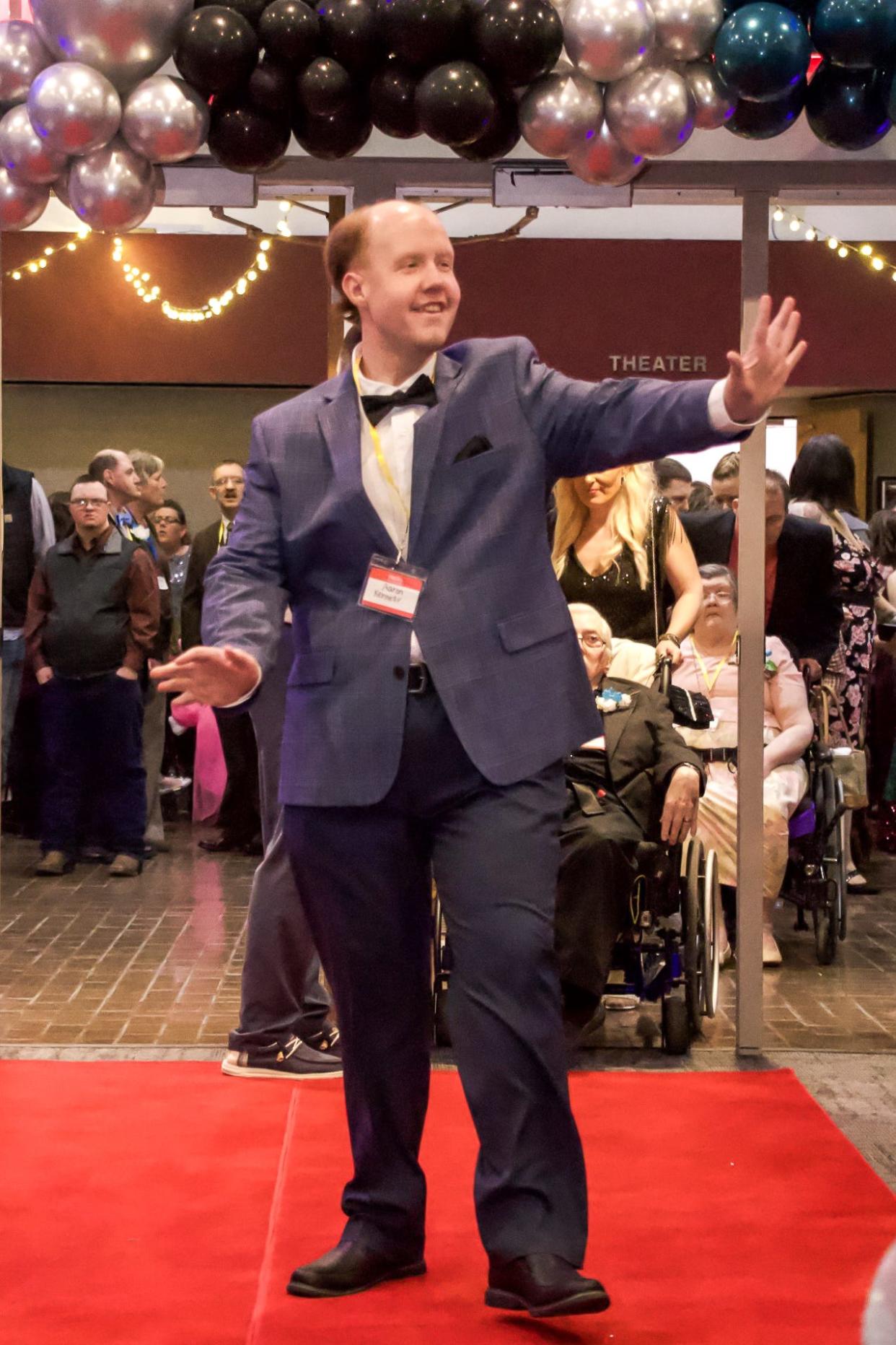 Aaron Kennedy walks the red carpet as he enters the Night to Shine event at Pritchard Laughlin Civic Center.