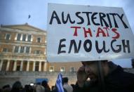 A protester displays his sign during an anti-austerity, pro-government demonstration outside the Greek parliament in Athens on the eve of a crucial euro zone finance minister's meeting to discuss the country's future, February 11, 2015. REUTERS/Yannis Behrakis