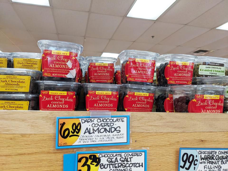Containers of dark chocolate-covered almonds on a shelf at Trader Joe's.