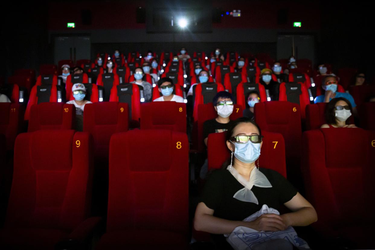 People wearing face masks to protect against the coronavirus sit spaced apart as they watch the film "Dolittle" at a movie theater in Beijing, China on July 24, 2020. Beijing partially reopened movie theaters on Friday as the threat from the coronavirus continues to recede in China’s capital.