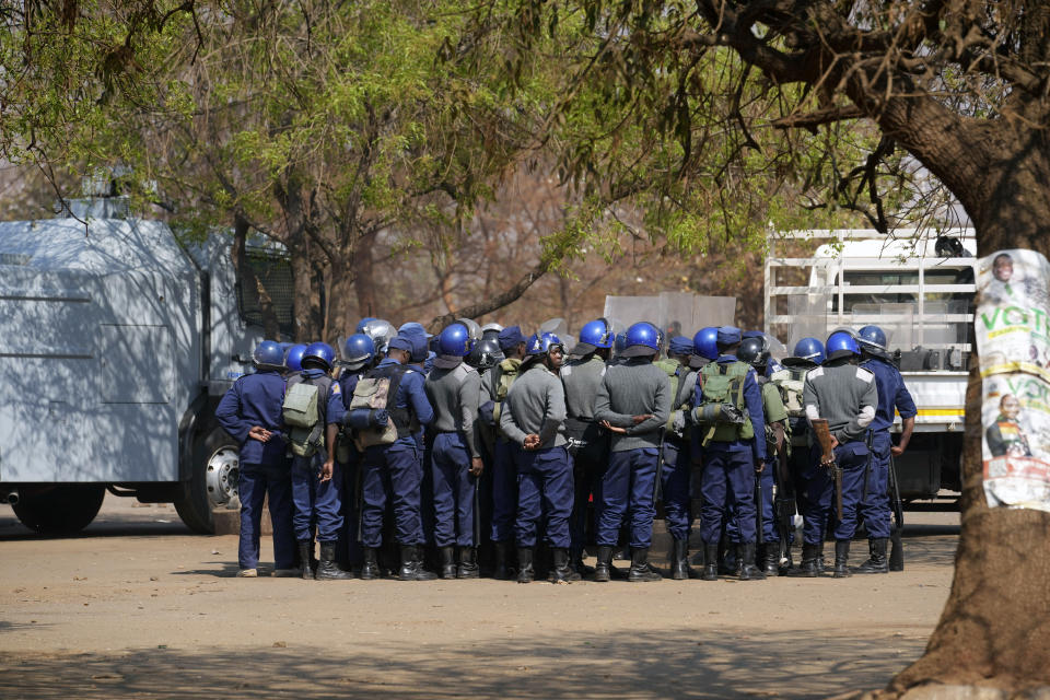 Armed riot police prepare to be deployed on the streets of Harare, Zimbabwe, Friday, Aug. 25, 2023. Hordes of police officers armed with batons, teargas canisters and some with guns were seen next to the result centre as Zimbabweans anxiously waited for the outcome of general elections after polls closed on Thursday and authorities tightened security around the results centre. (AP Photo/Tsvangirayi Mukwazhi)