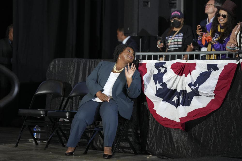 Georgia Democratic gubernatorial candidate Stacey Abrams waves to a supporter as she listens to former President Barack Obama speak during a campaign rally, Friday, Oct. 28, 2022, in College Park, Ga. (AP Photo/John Bazemore)