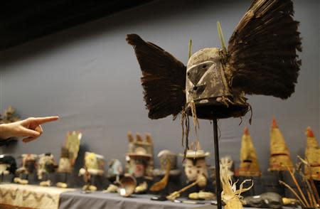 A man looks at an antique tribal mask, Tumas Crow Mother, circa 1860-1870, revered as a sacred ritual artifact by the Native American Hopi tribe in Arizona, which is displayed at the Drouot auction house ahead of a sale in Paris December 9, 2013. REUTERS/Christian Hartmann