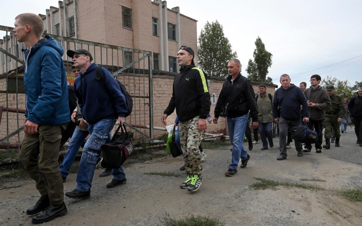 Russian recruits walk past a military recruitment center in Volgograd, Russia - AP Photo