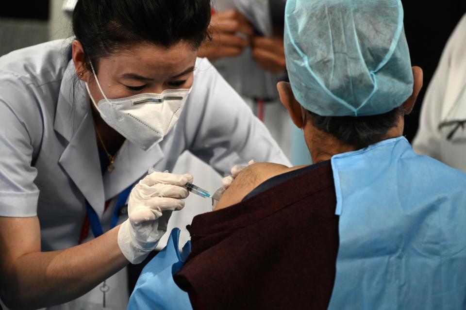 A medical worker inoculates a colleague with a Covid-19 coronavirus vaccine at the All India Institute of Medical Science (AIIMS) in New Delhi in January 16, 2021. (Photo by Sajjad HUSSAIN / AFP) (Photo by SAJJAD HUSSAIN/AFP via Getty Images)