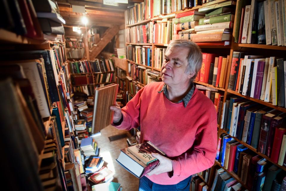 Douglas Swarthout, owner of Berry Hill Book Shop, organizes some books by category on a shelve. Swarthout said visitors range from older people — book collectors or those selling books as they downsize or move — and younger people interested in used books.