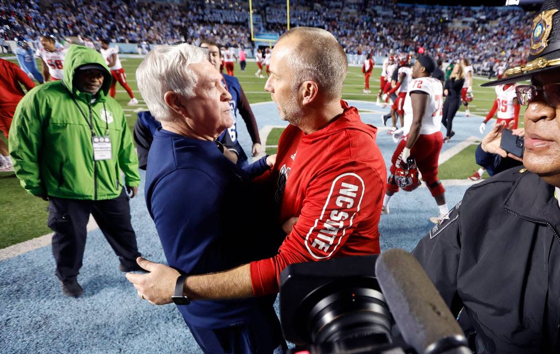 N.C. State head coach Dave Doeren talks with North Carolina head coach Mack Brown after N.C. State’s 30-27 overtime victory over UNC at Kenan Stadium in Chapel Hill, N.C., Friday, Nov. 25, 2022. Ethan Hyman/ehyman@newsobserver.com