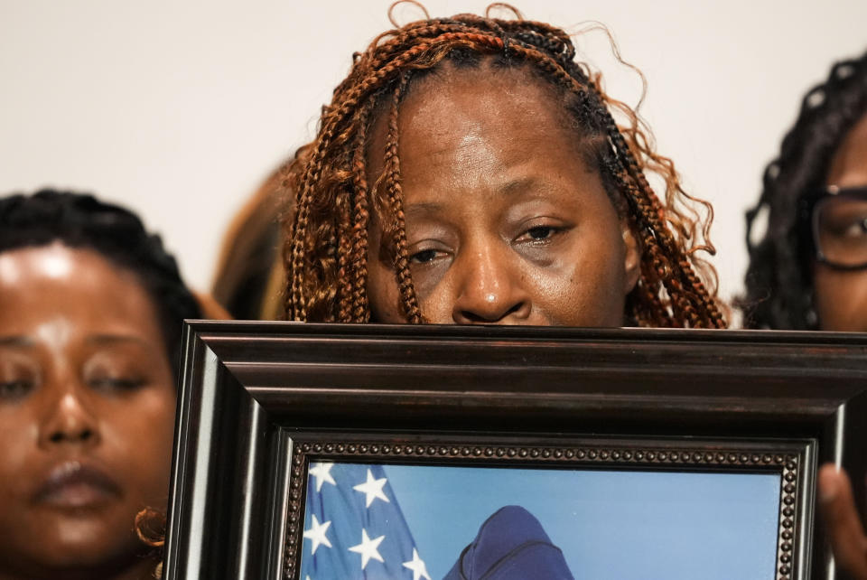 Chantemekki Fortson, mother of Roger Fortson, a U.S. Navy airman, holds a photo of her son during a news conference regarding his death, along with family and Attorney Ben Crump, Thursday, May 9, 2024, in Fort Walton Beach, Fla. Fortson was shot and killed by police in his apartment on May 3, 2024. (AP Photo/Gerald Herbert)