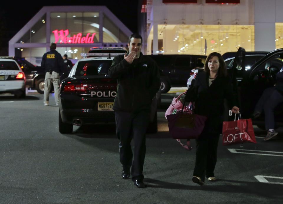 People leave as police secure the area after reports that a gunman fired shots at the Garden State Plaza mall in Paramus, New Jersey, November 4, 2013. A person with a gun opened fire on Monday evening in the New Jersey shopping mall shortly before closing time in the town of Paramus, and the mall was being evacuated, a county official said. (REUTERS/Ray Stubblebine)