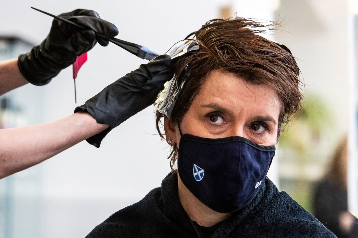 Scotland's first minister Nicola Sturgeon, wearing a face covering, is reflected in a mirror as she has her hair coloured and cut at Beehive Hair and Make up hairdressers' salon in Edinburgh on 5 April. Photo: Andy Buchanan/AFP via Getty Images