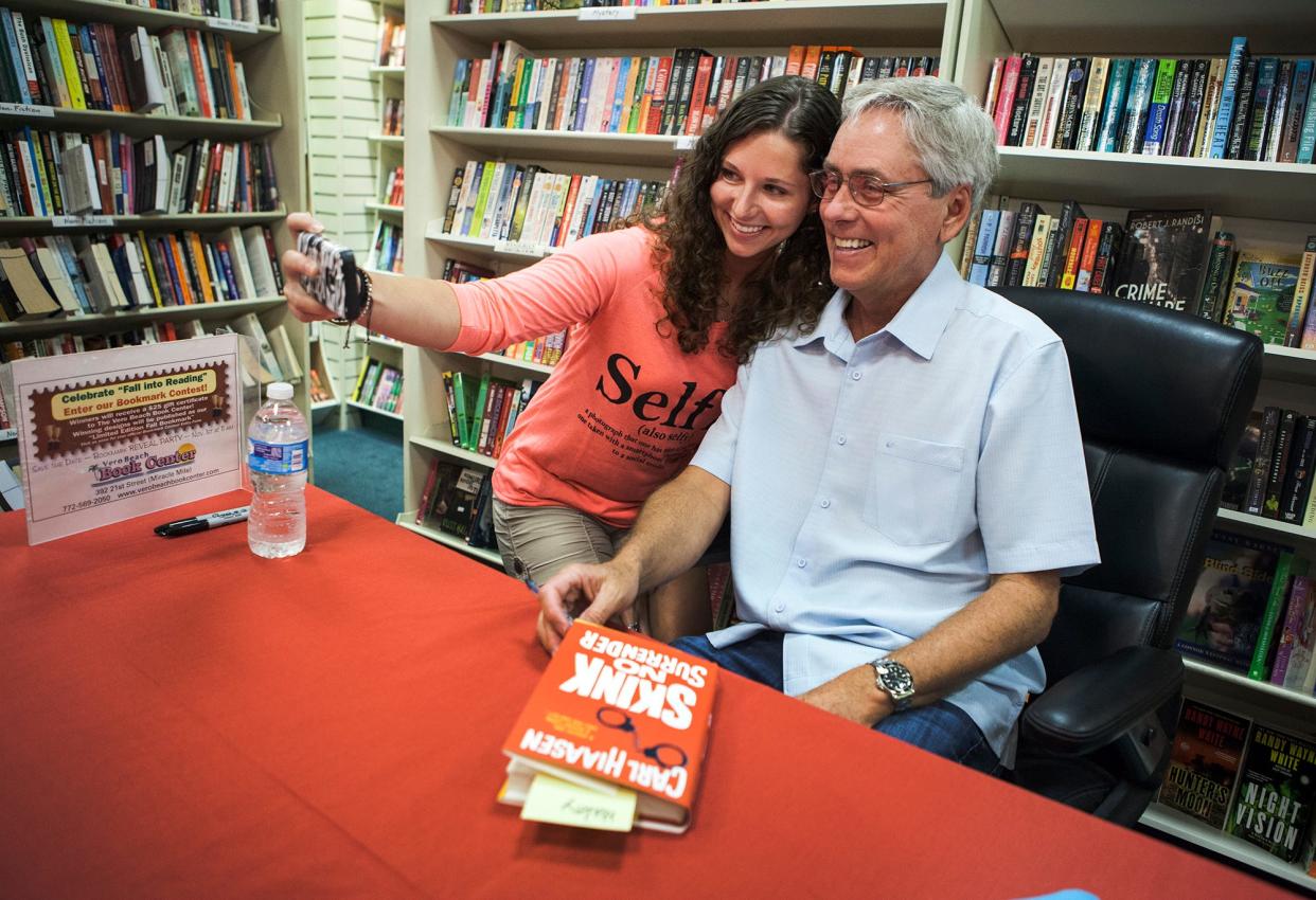 Best-selling author Carl Hiaasen takes a selfie with Haley Sanders, a fan from Melbourne, while signing copies of his book "Skink - No Surrender," at the Vero Beach Book Center in 2014.