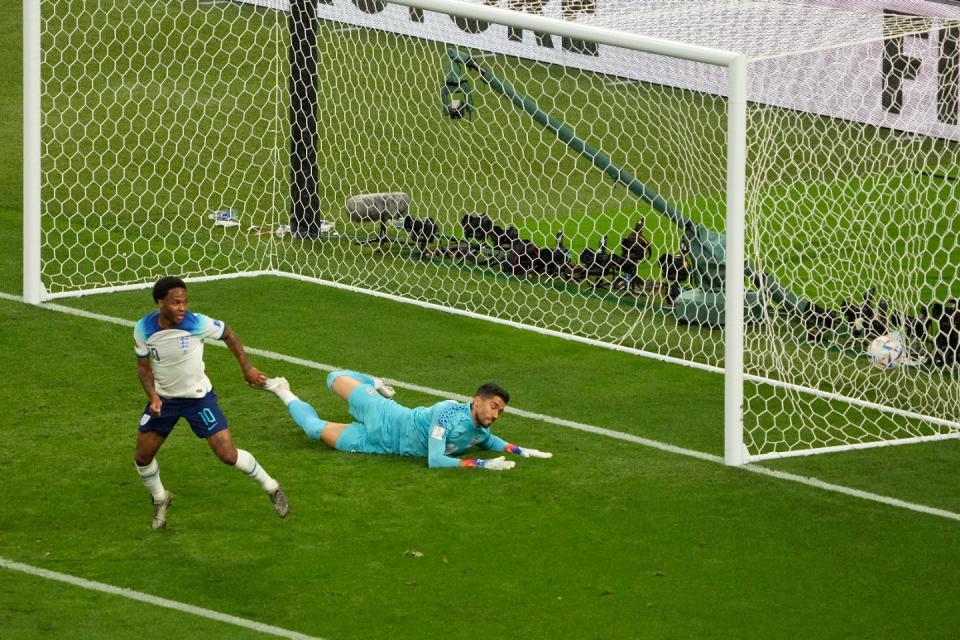 England's Raheem Sterling scores his side's third goal past Iran's Abolfazl Jalali during the World Cup group B football match between England and Iran at the Khalifa International Stadium in Doha, Qatar, Monday, Nov. 21, 2022. (AP Photo/Pavel Golovkin)