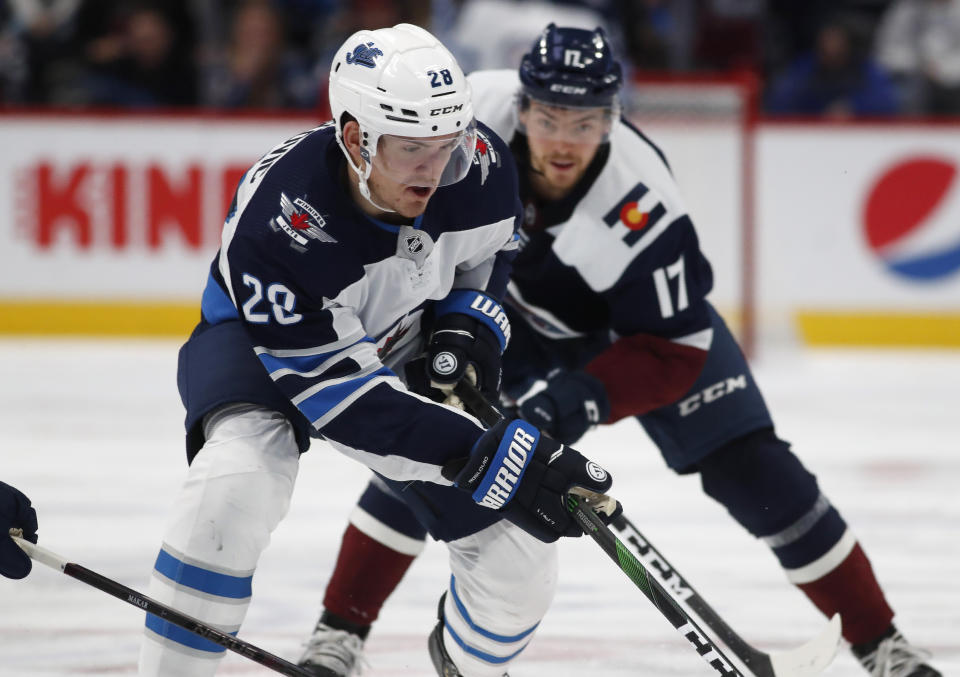 Winnipeg Jets center Jack Roslovic, front, wins a race to the puck in front of Colorado Avalanche center Tyson Jost during the second period of an NHL hockey game Tuesday, Dec. 31, 2019, in Denver. (AP Photo/David Zalubowski)