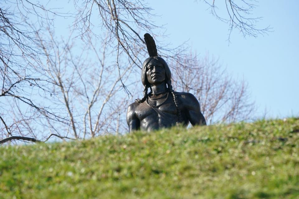 The statue of Chief Massasoit, the leader of the Wampanoag tribe, towers above people marching during the National Day of Mourning, on Thanksgiving day, November 25, 2021 in Plymouth, Massachusetts.