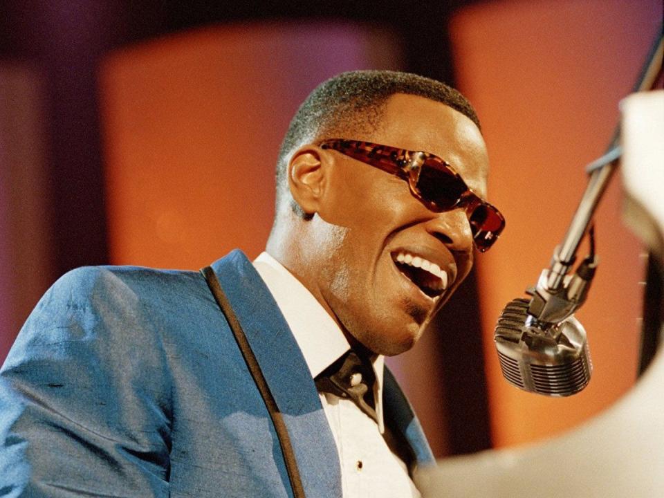 Jamie Foxx as Ray Charles singing into a mic