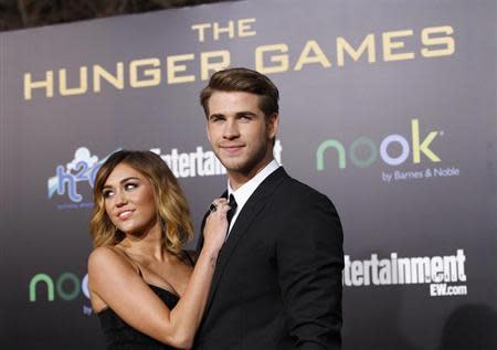 Cast member Liam Hemsworth poses with actress Miley Cyrus at the premiere of "The Hunger Games" at Nokia theatre in Los Angeles, California March 12, 2012 in this file picture. REUTERS/Mario Anzuoni