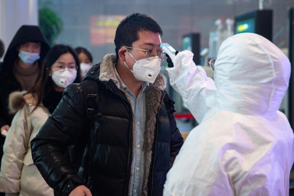 Medical staff check the temperature of passengers at Nanjing South Railway station in Nanjing, Jiangsu Province, China.