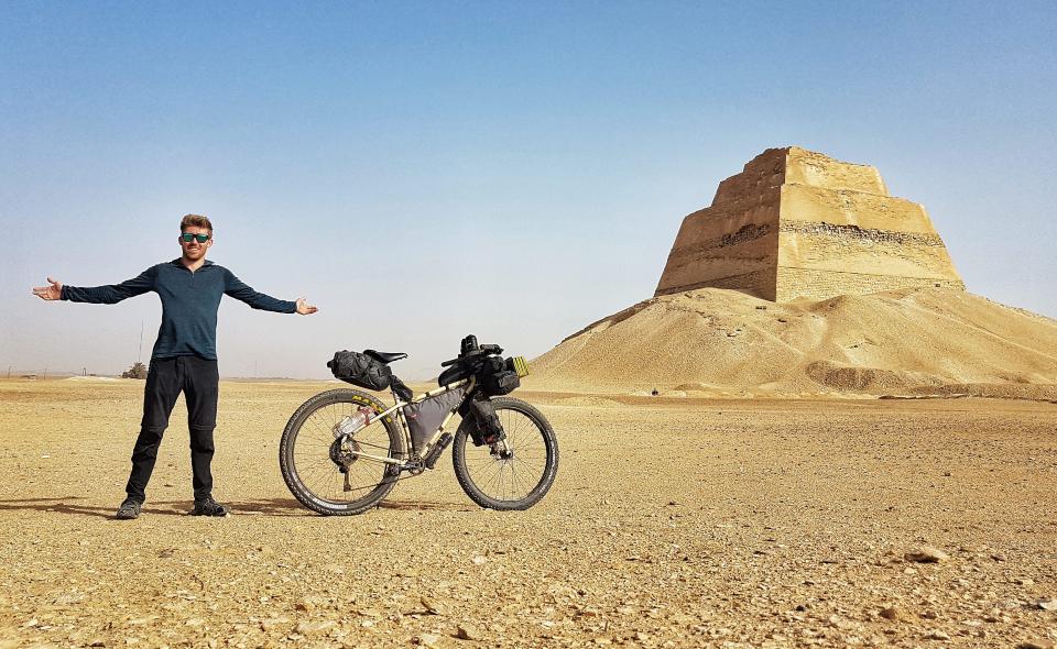 Man standing in front of pyramid in Egypt.