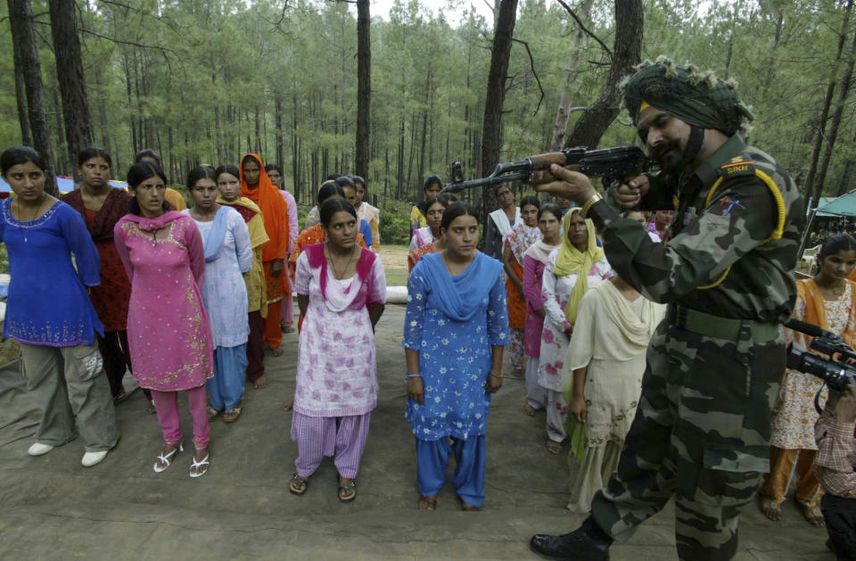 FILE- Women Village Defense Committee (VDC) members look on during a training session by the Indian Army at Sariya village, in Naushera sector, about 140 kilometers (88 miles) northwest of Jammu, India, Aug. 11, 2007. The militia, was initially formed in the 1990s as the first line of defense against anti-India insurgents in remote Himalayan villages that government forces could not reach quickly. As the insurgency waned in their operational areas and as some militia members gained notoriety for brutality and rights violations, drawing severe criticism from human rights groups, the militia was largely disbanded. (AP Photo/Channi Anand, File)