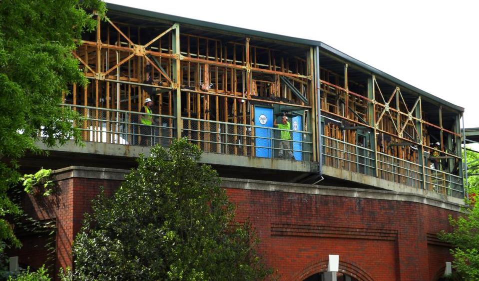 Workers carry debris to a dumpster while working on the suite level at Golden Park in Columbus, Georgia. 04/17/2024 Mike Haskey/mhaskey@ledger-enquirer.com