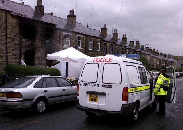 A police officer stands guard outside the house in Osborne Road after the fire