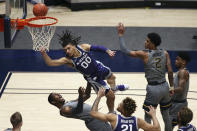 Kansas State guard Mike McGuirl (00) shoots while defended by West Virginia forwards Gabe Osabuohien (3) and Jalen Bridges (2) during the second half of an NCAA college basketball game Saturday, Feb. 27, 2021, in Morgantown, W.Va. (AP Photo/Kathleen Batten)