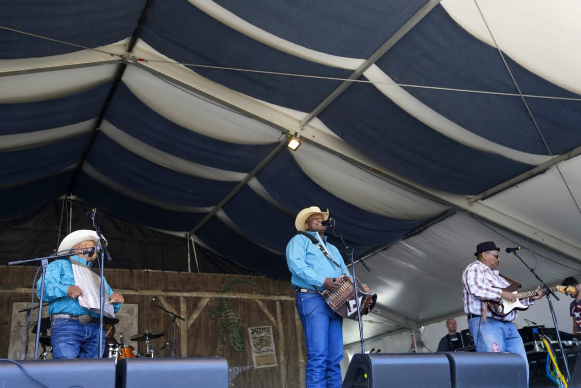 Gino Delafose plays the accordion as he performs with the Gino Delafose & French Rockin’ Boogie zydeco band at the New Orleans Jazz & Heritage Festival in New Orleans, Friday, April 28, 2023. (AP Photo/Gerald Herbert)