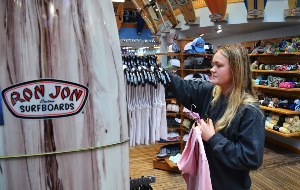 Kaityn Wyrsch, a spring-break visitor from IBMC College in Greeley, Colorado, checks out T-shirts and hoodies at Ron Jon Surf Shop in Cocoa Beach.