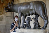 Una visitante con una máscara facial para prevenir el COVID-19 mira una escultura de la loba alimentando a Rómulo y Remo en los Museos Capitolinos de Roma el martes 19 de mayo de 2020. Los museos han reabierto dudosos a medida que se relajan las medidas de confinamiento por el coronavirus, pero los expertos señalan que uno de cada ocho museos podría cerrar permanentemente por la pandemia. (Foto AP/Alessandra Tarantino)