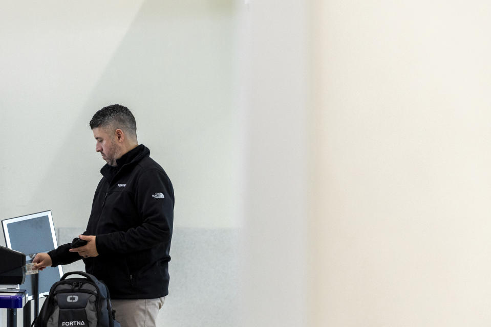 A traveler inserts his ID card while using the Transportation Security Administration's new facial recognition technology at a Baltimore-Washington International Thurgood Marshall Airport security checkpoint, Wednesday, April 26, 2023, in Glen Burnie, Md. (AP Photo/Julia Nikhinson)