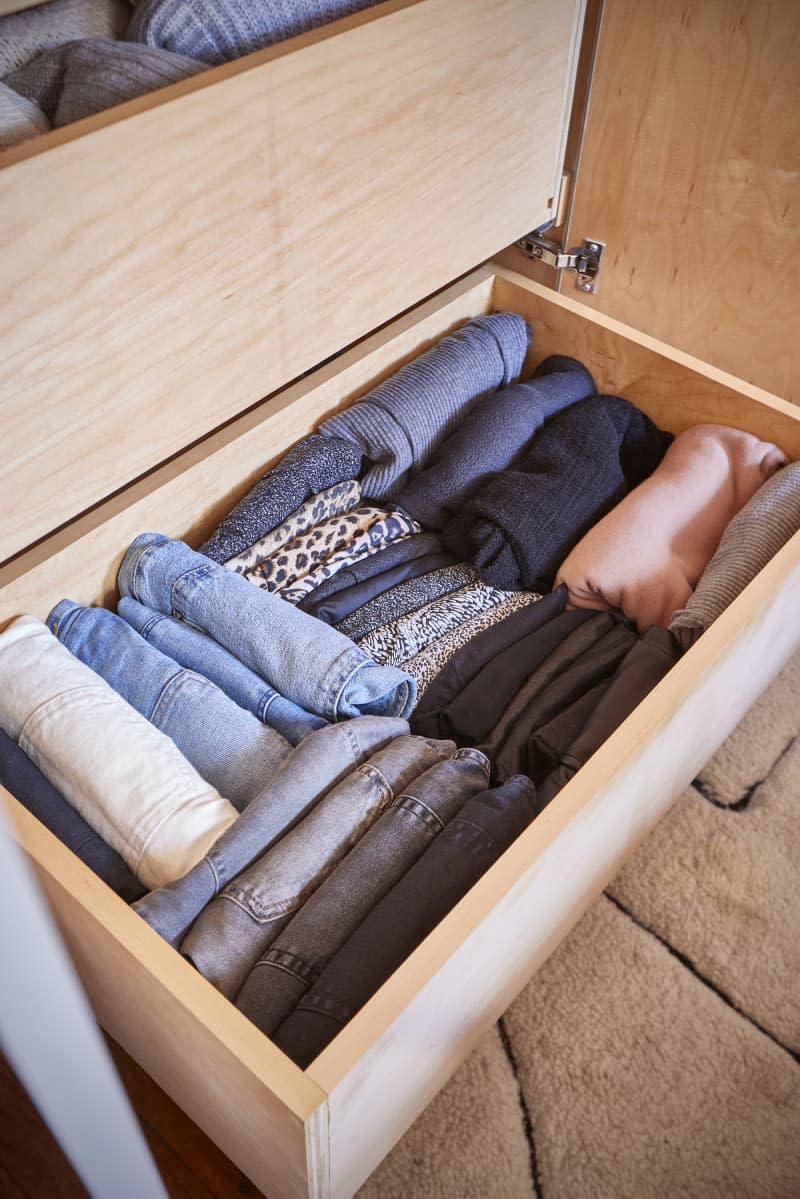 Neatly folded jeans in closet drawer.