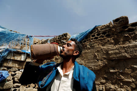 Man drinks water at his house after he collected water from a public tap amid a cholera outbreak in Sanaa, Yemen July 4, 2017. Picture taken July 4, 2017. REUTERS/Khaled Abdullah