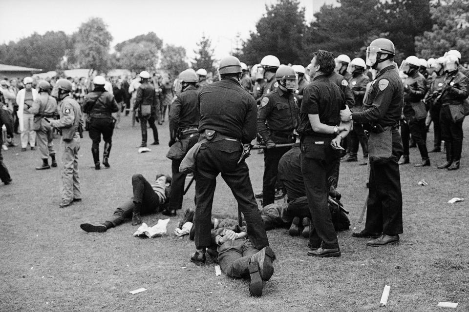 Several members of the San Francisco police department stand over handcuffed demonstrators after the confrontation on the San Francisco State College campus, Dec. 7, 1968.