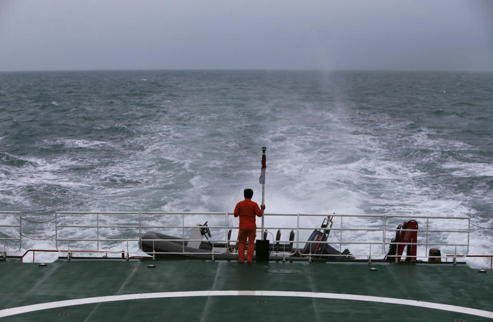 A rescue member stands on the deck of SAR ship KN Purworejo during a search operation for passengers onboard AirAsia flight QZ8501, in Java Sea, Indonesia January 3, 2015. Indonesia search and rescue teams hunting for the wreck of an AirAsia passenger jet have located four large objects in the Java Sea, agency chief Fransiskus Bambang Soelistyo told reporters on Saturday. The Indonesia AirAsia Airbus A320-200 plunged into the Java Sea on Sunday while en route from Indonesia's second-biggest city Surabaya to Singapore with 162 people on board. No survivors have been found. REUTERS/Beawiharta (INDONESIA - Tags: DISASTER TRANSPORT)