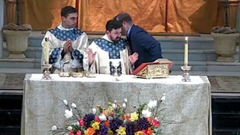 As the incident unfolded, a parishioner approached the altar to whisper in the ear of associate pastor Father Nicholas DuPré. - St. Mary Magdalen Catholic Church