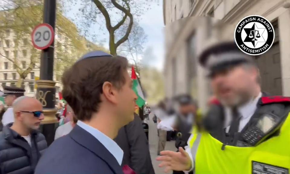 Gideon Falter speaks with a police officer during the march (Campaign Against Antisemitism/PA Wire)
